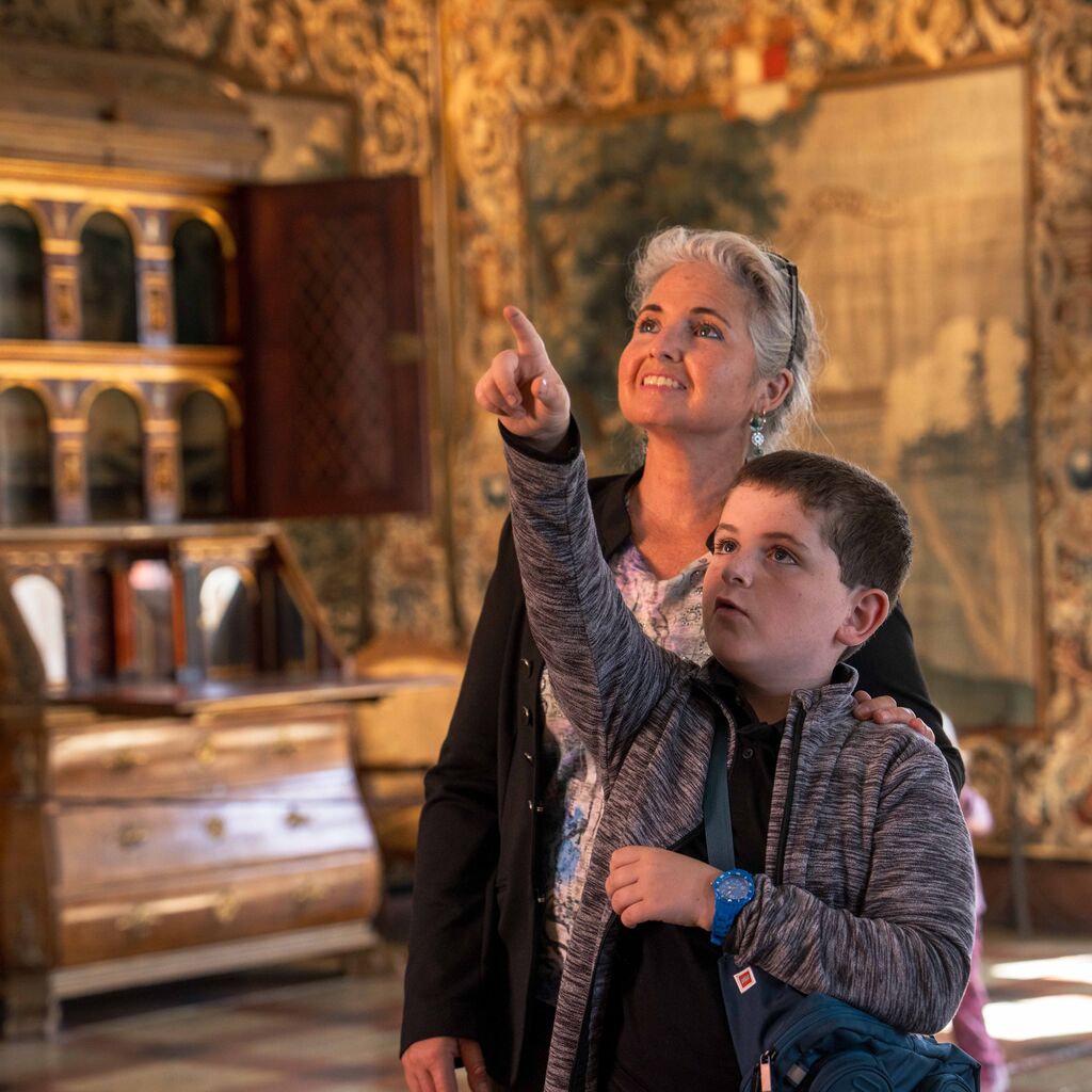 Mor og dreng, der peger opad på noget i Riddersalen på Gammel Estrup