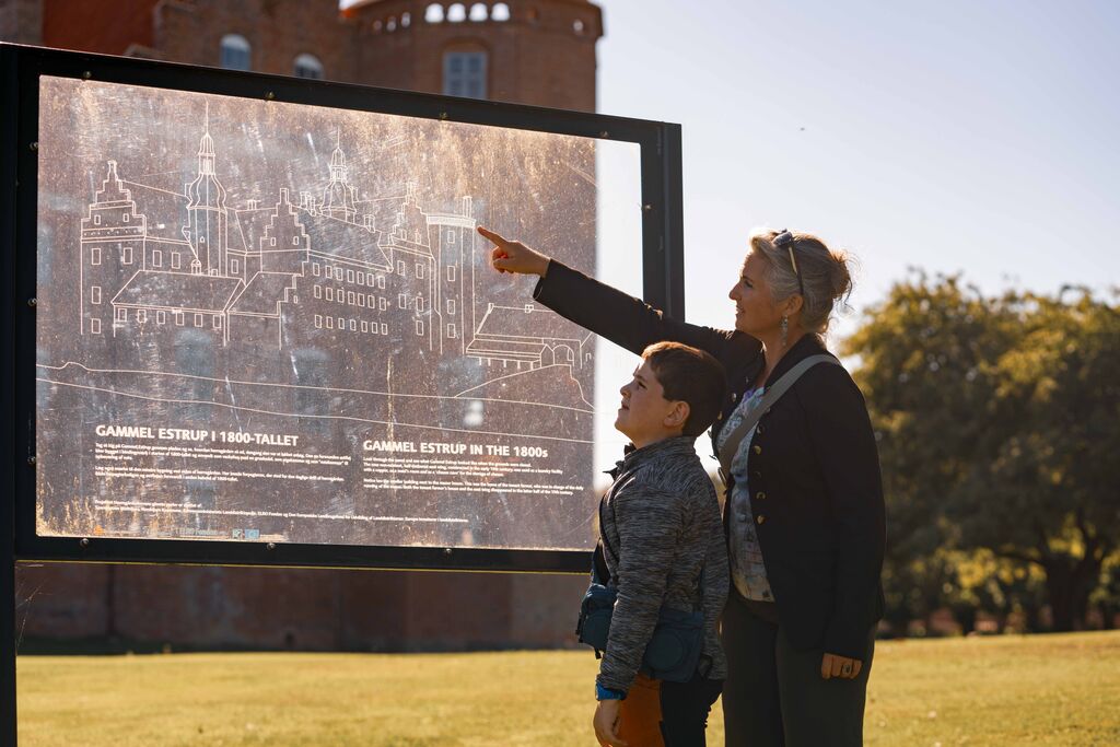 Mor og søn ved informationstavle på Gammel Estrup